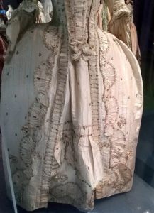 Detail of cream dress skirt front showing furbelows